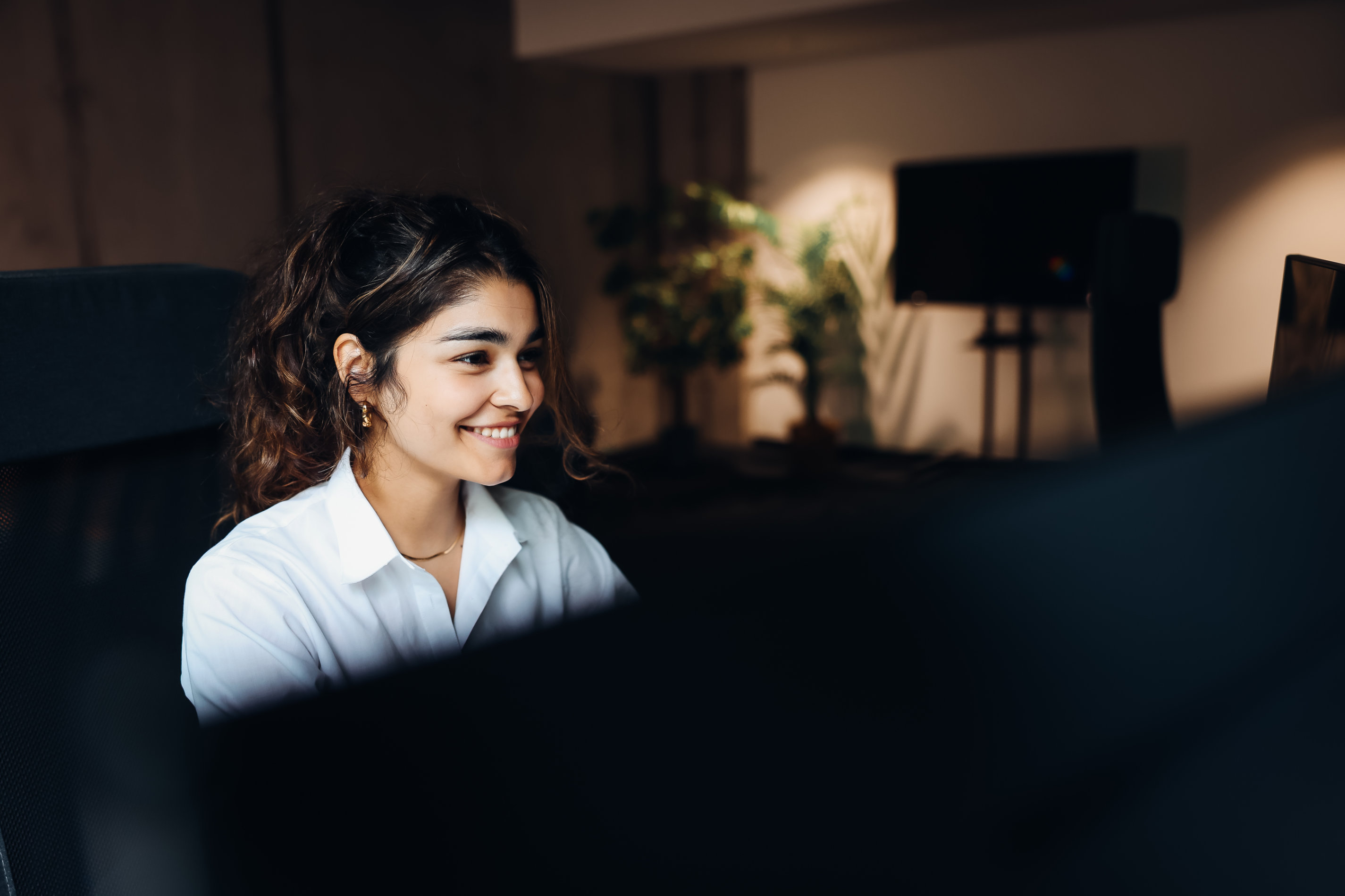 Eine IT-Support-Mitarbeiterin sitzt an ihrem Schreibtisch und bearbeitet Kundenanfragen. Sie hilft Unternehmen bei technischen Problemen und optimiert digitale Prozesse für eine reibungslose IT-Infrastruktur.