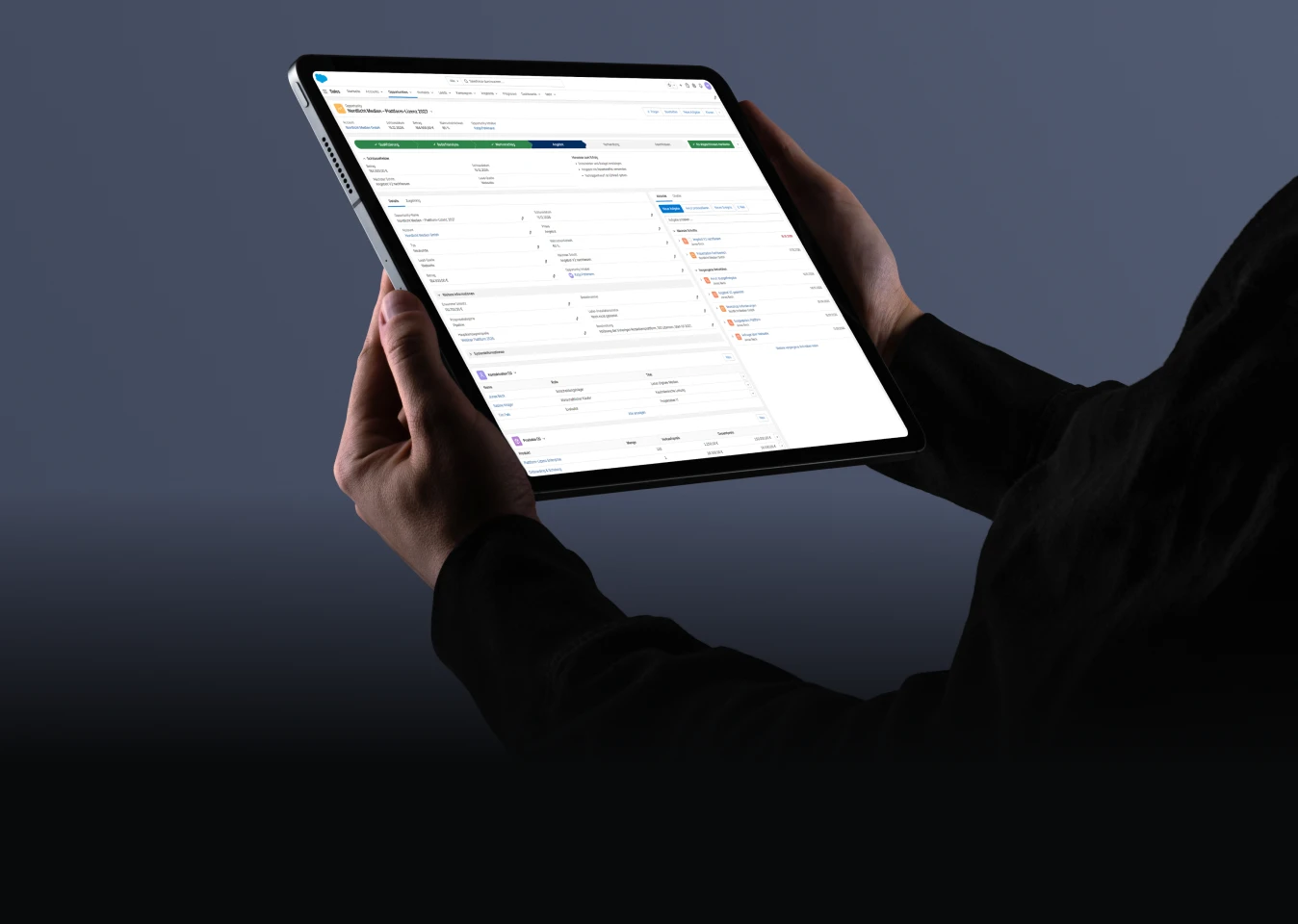 Person hält ein Tablet mit geöffneter Business-Anwendung für digitale Arbeitsprozesse.