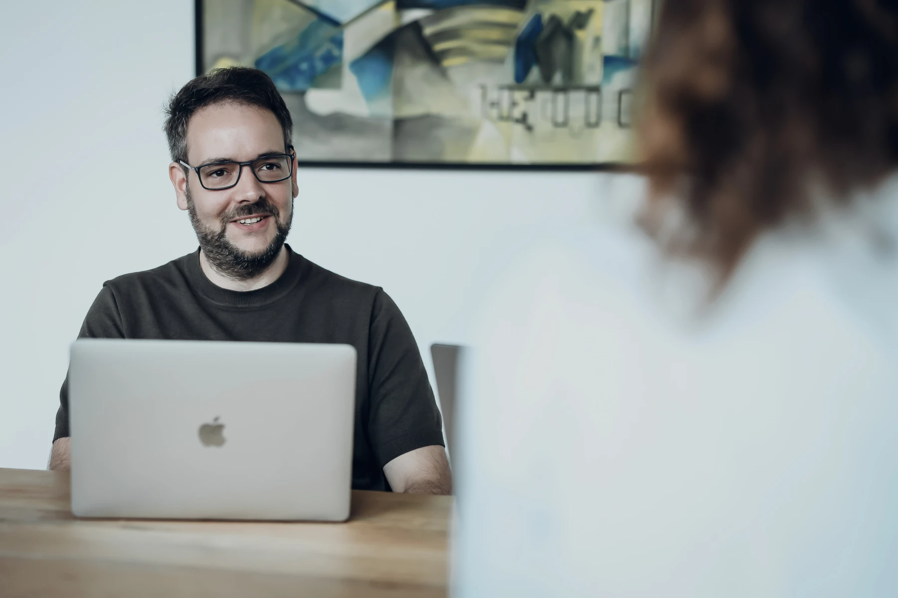 Mann mit Laptop im Gespräch in einem Büro bei Schwekas